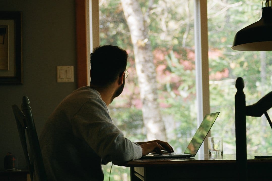 man-at-desk-with-laptop-looking-into-the-distance.jpg