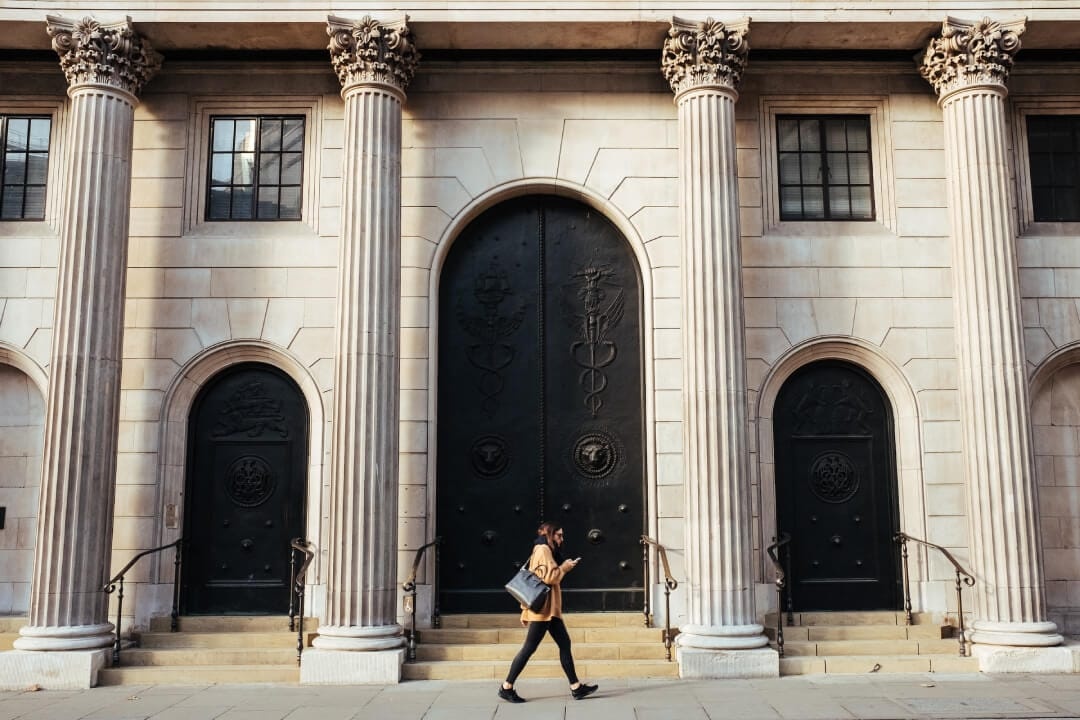 person-walking-infront-of-white-building-with-ionic-pillars.jpg