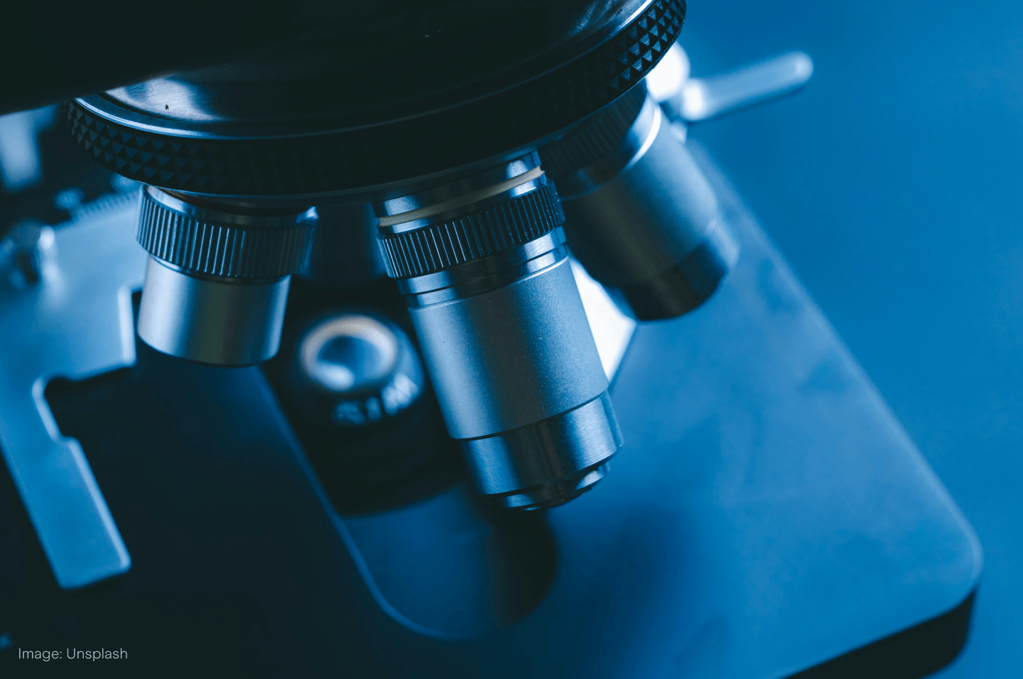 A large and powerful microscope on a metallic blue background